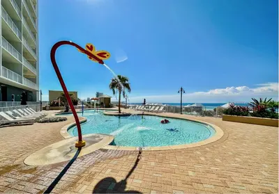 a pool with a fountain in the middle of a building at Bright & Spacious Condo 1BD! Steps from the Beach! by Dolce Vita Getaways PCB in Panama City Beach