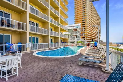 a swimming pool at a resort with chairs and a building at 1202 Seychelles in Panama City Beach