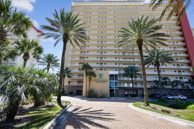 a large building with palm trees in front of it at 1105 Sterling Beach in Panama City Beach