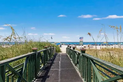 a boardwalk leading to a beach with the ocean at Grand Panama Beach Resort Tower 2 by Panhandle Getaways in Panama City Beach