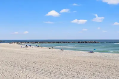 a group of people on a beach with the ocean at Commodore 0702 in Panama City Beach
