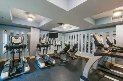 a gym with several cardio machines in a row at Calypso 1-202 by Emerald Coast Retreats in Panama City Beach