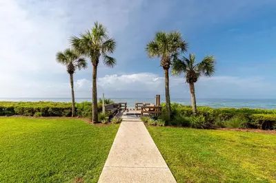 a walkway leading to the ocean with palm trees at Palms of Seagrove D5 in Santa Rosa Beach