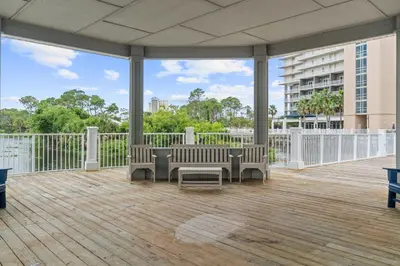 a patio with chairs and a table on a deck at Lake-View Condo Near Beach,5 Pools, 2 Hot Tubs, Balcony & Resort Amenities in Panama City Beach