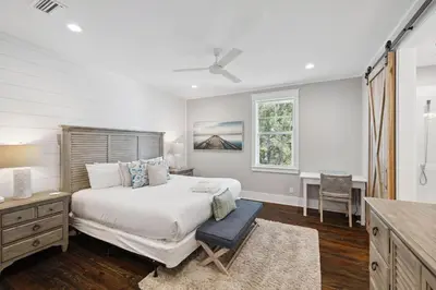 a bedroom with a bed and a desk and a window at Om Sweet Om in Seagrove Beach