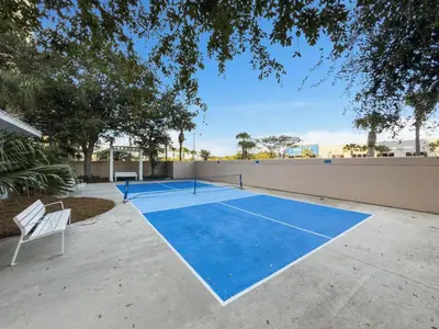 a tennis court in the middle of a driveway at Beach Resort Condo with 5 Pools! Steps to Beach! by Dolce Vita Getaways PCB in Panama City Beach