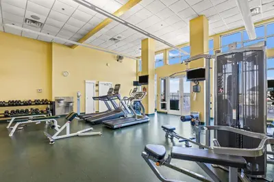 a gym with several treadmills and cardio machines at Grand Panama Beach Resort - Pet Friendly Condos by Panhandle Getaways in Panama City Beach