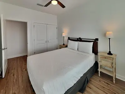 a bedroom with a large white bed and a night stand at Sunset on Snapper C in Panama City Beach
