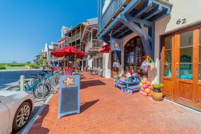 a street with shops and a car parked on a sidewalk at 30A Hideaway l Ocean Views l Across street from beach l Rosemary Beach in Inlet Beach