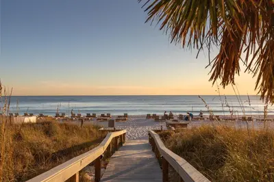 a boardwalk leading to the beach at sunset at Commodore 0809 in Panama City Beach