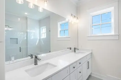 a white bathroom with two sinks and a large mirror at 30A Sunrise and Sunset in Santa Rosa Beach