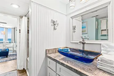 a bathroom with a blue sink and a mirror at Perching Pretty at Sunbird in Panama City Beach