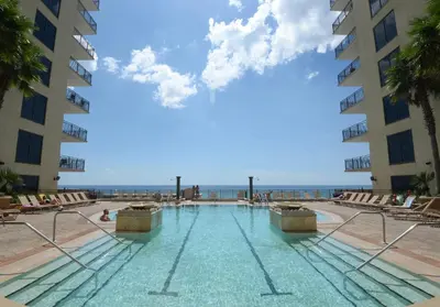 a swimming pool with the ocean in the background at Origins at Seahaven 819 in Panama City Beach