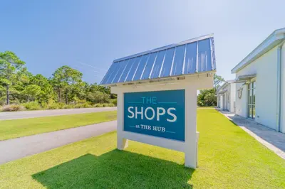 a sign in the grass in front of a building at Commodores 101 l Beachfront l Corner Unit with Pristine Beach Views l Community Pool in Santa Rosa Beach