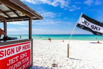 a sign on a beach with a flag on it at Origin at Seahaven 402 in Panama City Beach