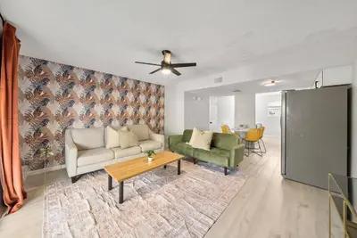 a living room with a couch and a table at Disco Dolphin – Your Funky Beachside Haven in PCB in Panama City Beach