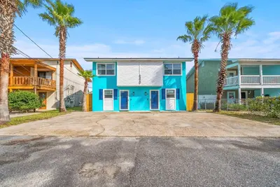 a house with palm trees in front of it at Disco Dolphin Compound | 2x PCB Private Retreats! in Panama City Beach