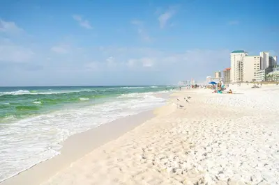 a beach with people and the ocean and buildings at 5 Min Walk to Sand - King Bed - Private Yard in Panama City Beach
