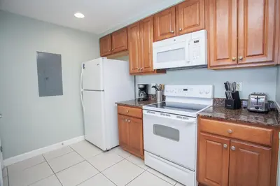 a kitchen with white appliances and wooden cabinets at Splash 1701E - 2BD in Panama City Beach