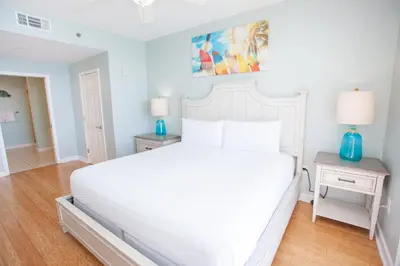 a white bed in a bedroom with two night stands at Splash 1701E - 2BD in Panama City Beach
