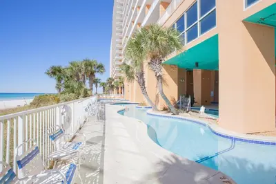 a resort swimming pool with chairs and the beach at Splash 1701E - Studio in Panama City Beach