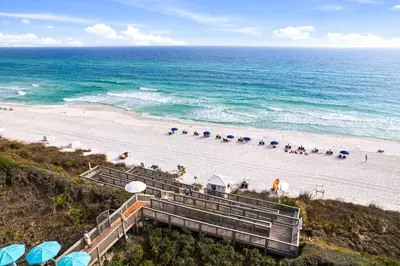 a beach with stairs and umbrellas and the ocean at HP 42W Peaceful Nest by 30A Escapes in Rosemary Beach