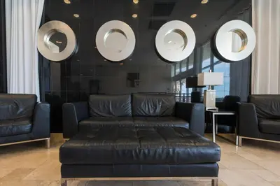 a living room with a leather couch and mirrors at Sterling Breeze 307A by Emerald Coast Retreats in Panama City Beach