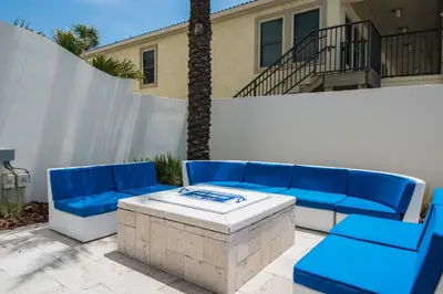 a patio with a blue couch and a table at Sterling Breeze 307A by Emerald Coast Retreats in Panama City Beach