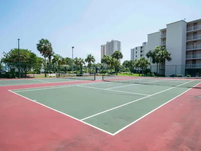 a tennis court in a city with buildings at Dunes of Panama #B501 in Panama City Beach