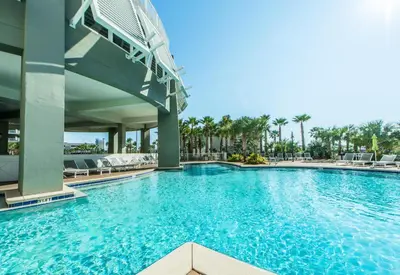a swimming pool at a resort with chairs and palm trees at Laketown Wharf 2031 in Panama City Beach