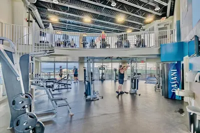 a gym with a man exercising in the gym at Beach-Ready Resort Condo! Pools & Walk to Beach by Dolce Vita Getaways in Panama City Beach