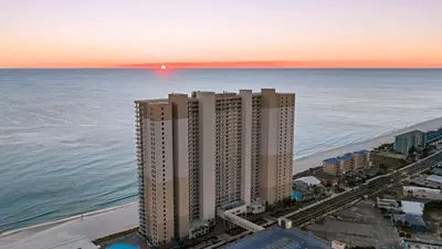 an aerial view of a building on the beach at sunset at Beachfront Tidewater Resort Condo w Pools Hot Tubs Pier Park Nearby Tidewater Beach by AvantStay in Panama City Beach
