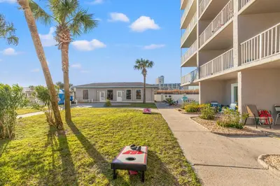 a house with a yard with palm trees at The Summit 922 - Relaxation meets the Shoreline in Panama City Beach
