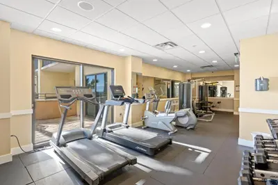 a gym with treadmills and elliptical machines at Origin 0525 - Studio King - Peaceful Nature View in Panama City Beach