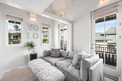 a living room with a couch and windows at YOLO Carriage in Rosemary Beach
