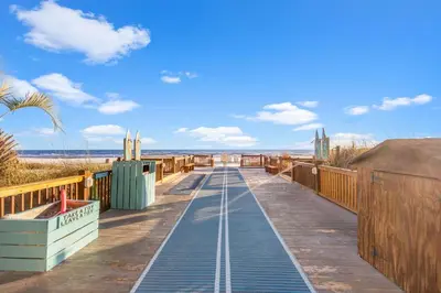 a boardwalk leading to the beach on a sunny day at The Summit 1421 - Wake to Gulf Views in Panama City Beach