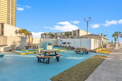 a group of picnic tables and benches on a sidewalk at The Summit 1132 - Beachfront Bliss Stunning 2BR in Panama City Beach
