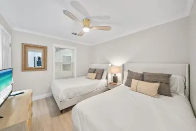 a bedroom with two beds and a flat screen tv at Beachside Villa 811 in Santa Rosa Beach