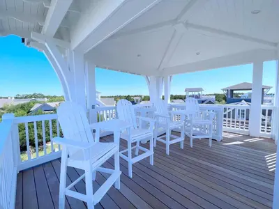 a white porch with white chairs and tables on a deck at Watersound 13 in Watersound Beach