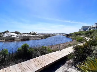 a wooden walkway over a river with a bridge at Watersound 13 in Watersound Beach