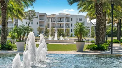a fountain in front of a building with palm trees at Salty Seabreeze in Seacrest