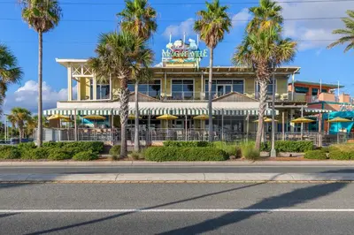 a hotel with palm trees in front of it at Buoy Oh Buoy! Sun, Sand, and Smiles Await! Sleeps 8! in Panama City Beach