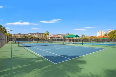 a tennis court with two tennis courts at Oh Buoy! Catch the Breeze at This Beachfront Escape! Sleeps 8! in Panama City Beach