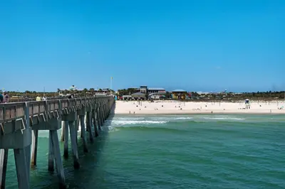 a pier over the ocean with a beach and people at Come enjoy some Seawaves! 2BR 25BA Sleeps 8! Coastal Townhome w/Beachview! in Panama City Beach
