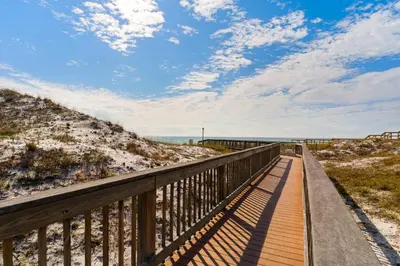a boardwalk to the beach on a sunny day at Gulf-front 3-bedroom condo with balconies off each bedroom & pickleball in Santa Rosa Beach