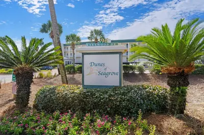a sign in front of a hotel with palm trees at Dog-friendly 4th-floor 3-bedroom condo with stunning Gulf views & pickleball in Santa Rosa Beach