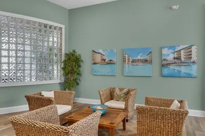 a living room with chairs and a table and paintings on the wall at Dog-friendly 4th-floor 3-bedroom condo with stunning Gulf views & pickleball in Santa Rosa Beach