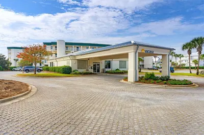 a building with a parking lot in front of it at Charming two-bedroom with bunks balcony overlooking pool & pickleball in Santa Rosa Beach