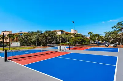 a tennis court with two tennis courts at Lovely condo with pool hot tub modern furnishings pickleball - near beach in Seacrest