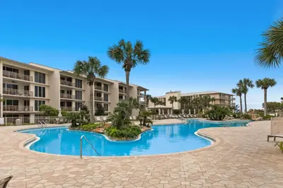 a pool at the resort with palm trees and condos at Elegant getaway with stunning view lagoon pool & pickleball - close to shops in Seacrest